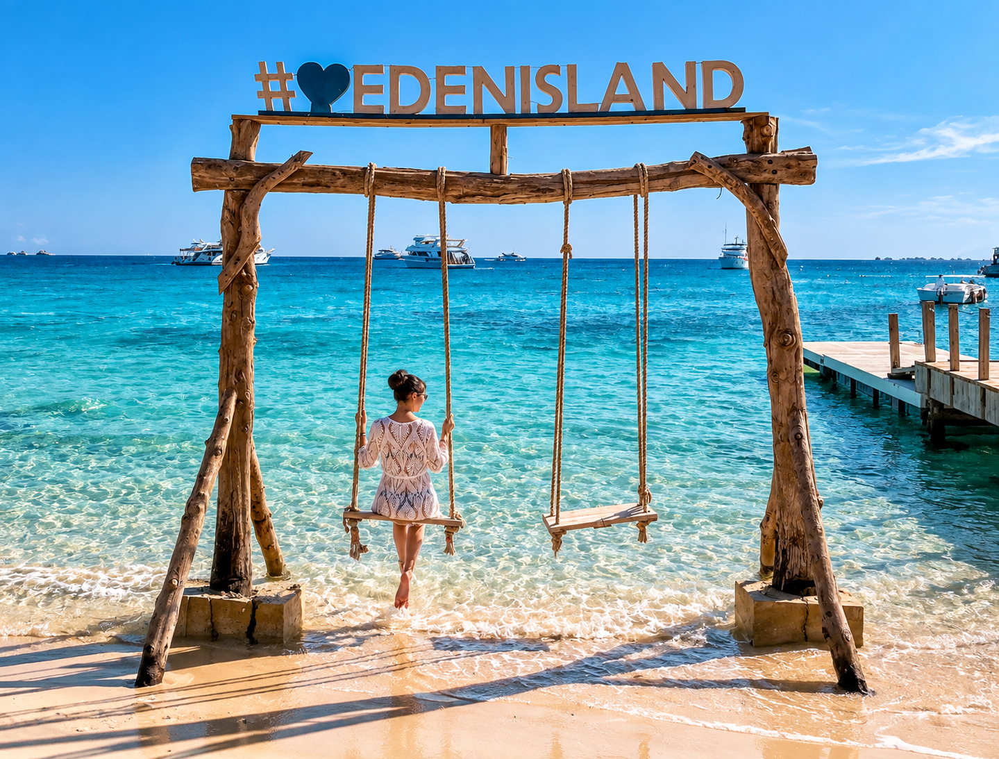 Balançoire en bois dans l'eau turquoise peu profonde d'Eden Island